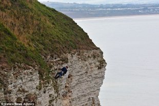 RSPCA officer Michael Pugh begins to abseil down the cliff face to rescue the bird at 8am
